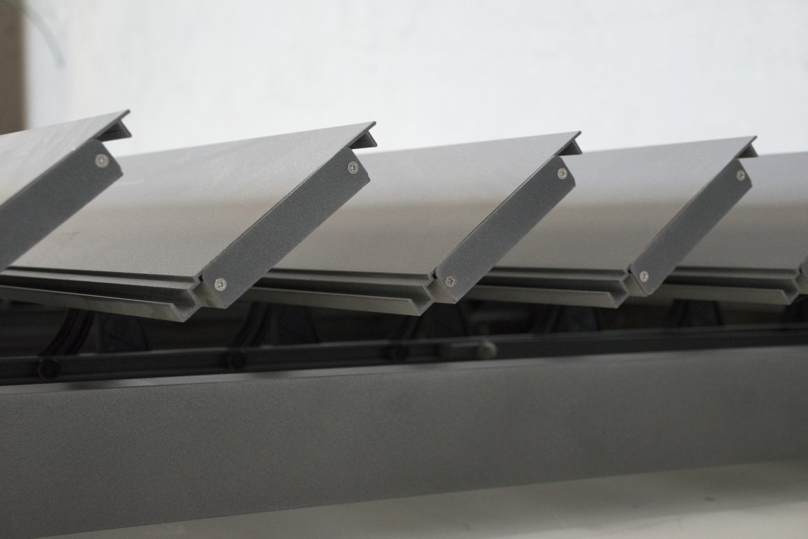 Vue rapprochée de lames en aluminium, alignées sur un cadre, idéales pour des volets ou des stores modernes.