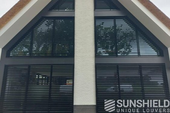 Façade avec des fenêtres modernes dotées de persiennes noires, idéal pour le style contemporain et la gestion de la lumière.